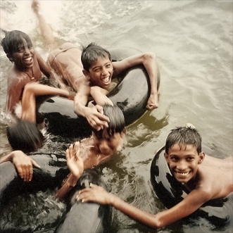 The hands of joyous boys playing near a jetty, Kerala Bakwaters